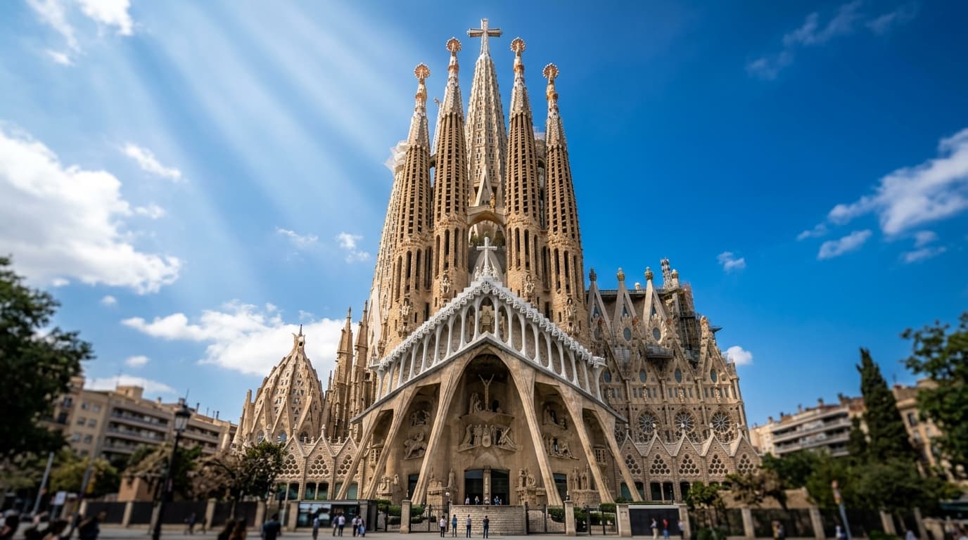 The soaring spires and Nativity façade of Sagrada Família in Barcelona under bright blue skies